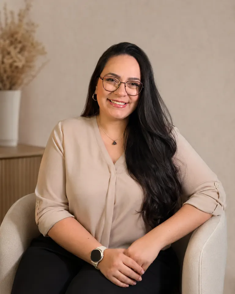 Géssica Jordão sentada em poltrona bege, sorrindo